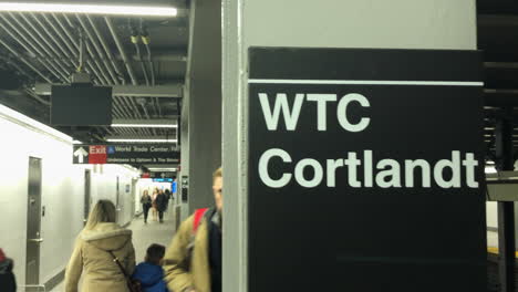 the world trade center cortlandt street subway station new york city.camera pans across wtc cortlandt sign on subway column with commuters walking behind it.