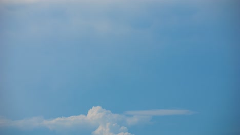 Cloud-moving-and-transforming-fast-in-deep-blue-sky-over-land-with