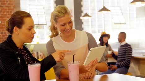 mujeres ejecutivas que usan tableta digital en el mostrador del café 4k