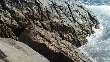 Slowmo-4k,-Eine-Hohe-Welle-Bricht-Gegen-Die-Gefährlichen-Felsen-Der-Küste,-Stärke-Und-Kraft-Der-Wellen,-Aufgewühltes-Meer