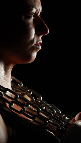 muscular woman wearing bandage and holding chain