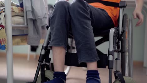 Close-up-low-angle-shot-disabled-young-guy-with-spinal-cord-and-leg-problems