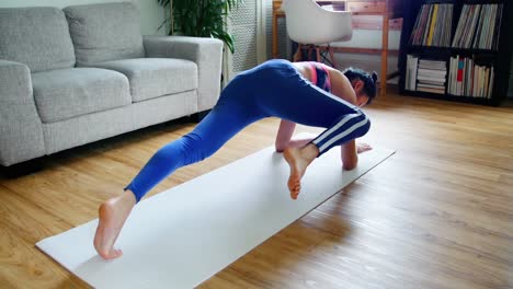 beautiful woman practicing yoga in living room