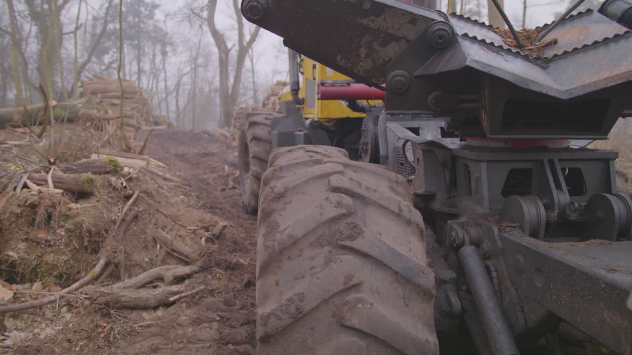 A tilting shot of a tree excavator in the middle of a destroyed forest.