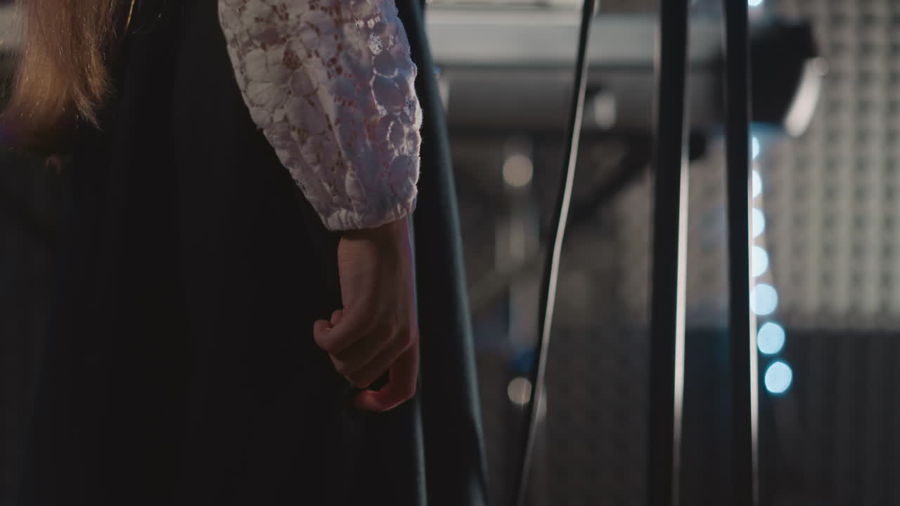 소녀가 드레스 위에 손가락을 달려 노래를 부르는 클로즈업 재능있는 걱정 어린 소녀는 무대에서 노래를 연주합니다. 쇼 동안 젊은 재능의 보컬 콘서트