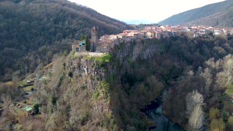 aerial drone circle castellfollit de la roca: the cliffside town in girona’s pyrenees, near garrotxa volcanic zone