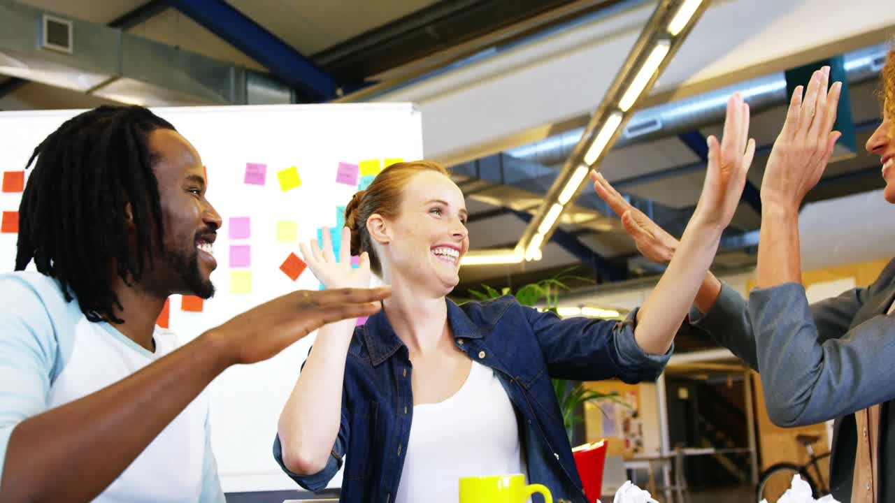 Businesspeople giving high five to each other