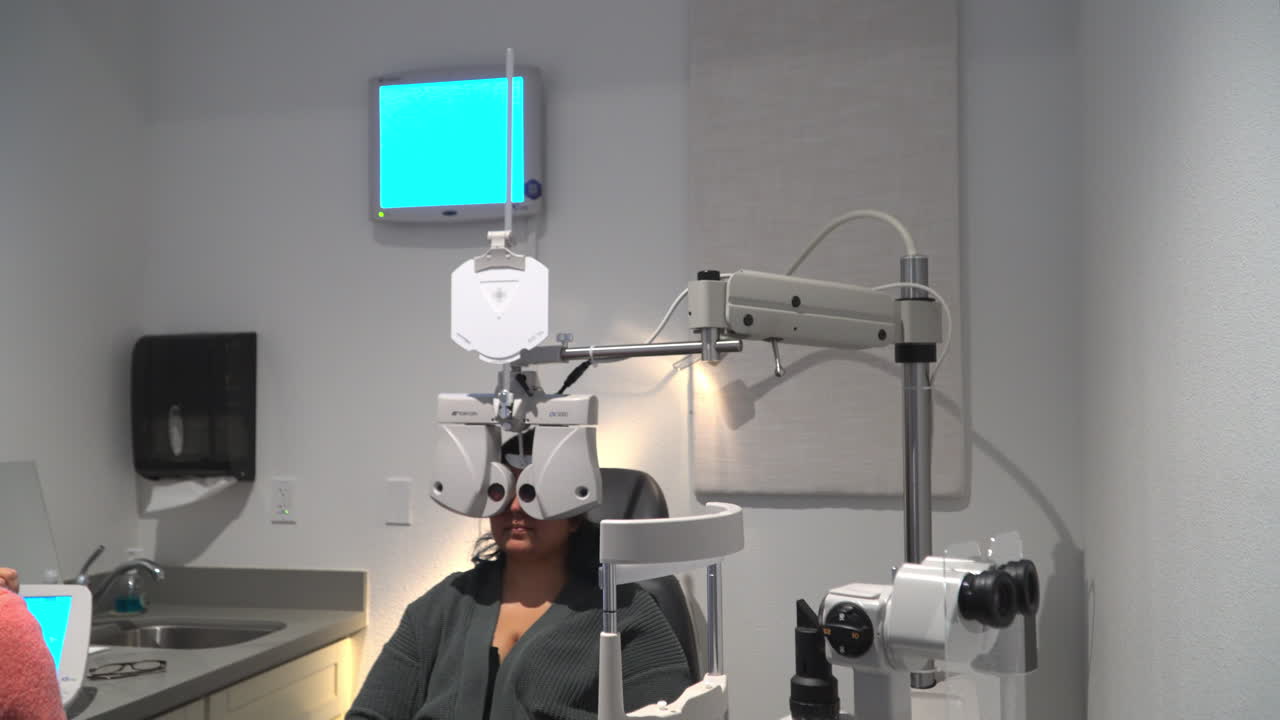 Prescription Lens Testing Using Phoropter - Patient Undergoing Eye Examination In Optometrist Clinic. - wide shot