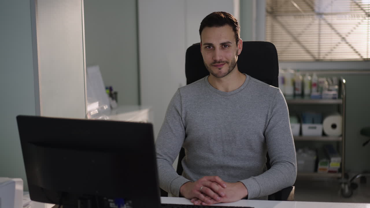 A man sitting at his desk in a medical office