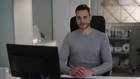 a man sitting at his desk in a medical office