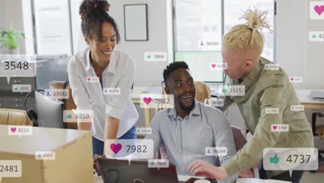anmation of social media icons against diverse colleagues discussing over a laptop at office
