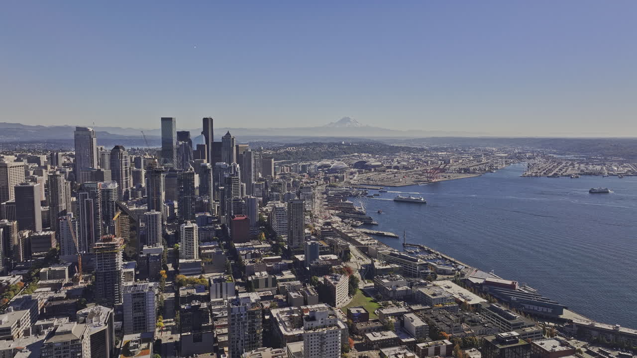 Seattle Washington Aerial v145 flyover Belltown capturing downtown cityscape, ferries crossing the waters and mountain backdrop under cloudless blue sky - Shot with Mavic 3 Pro Cine - Oct 6th 2023