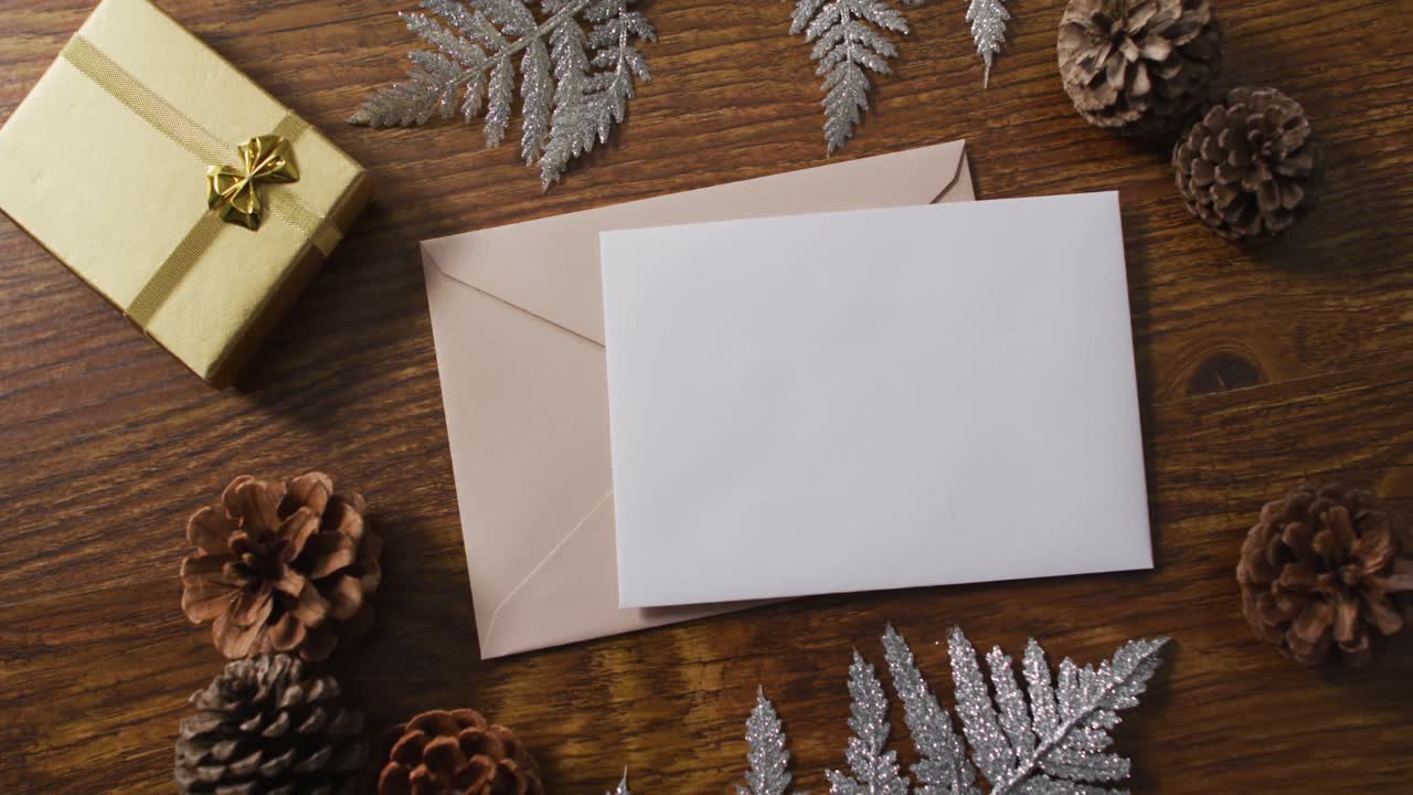 video de decoraciones de navidad con tarjeta blanca y sobre beige sobre fondo de madera