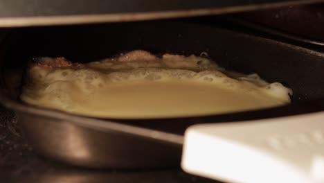 primer plano de fusión de queso raclette en fusión y burbujeo en el aparato de cocina