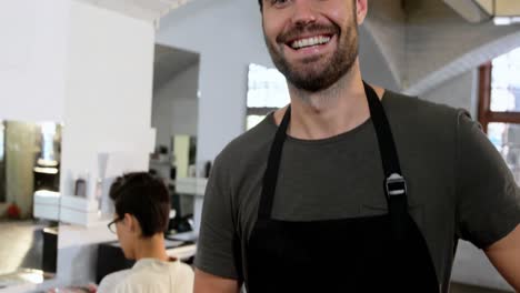 male hairdresser holding scissor, comb and brush in salon