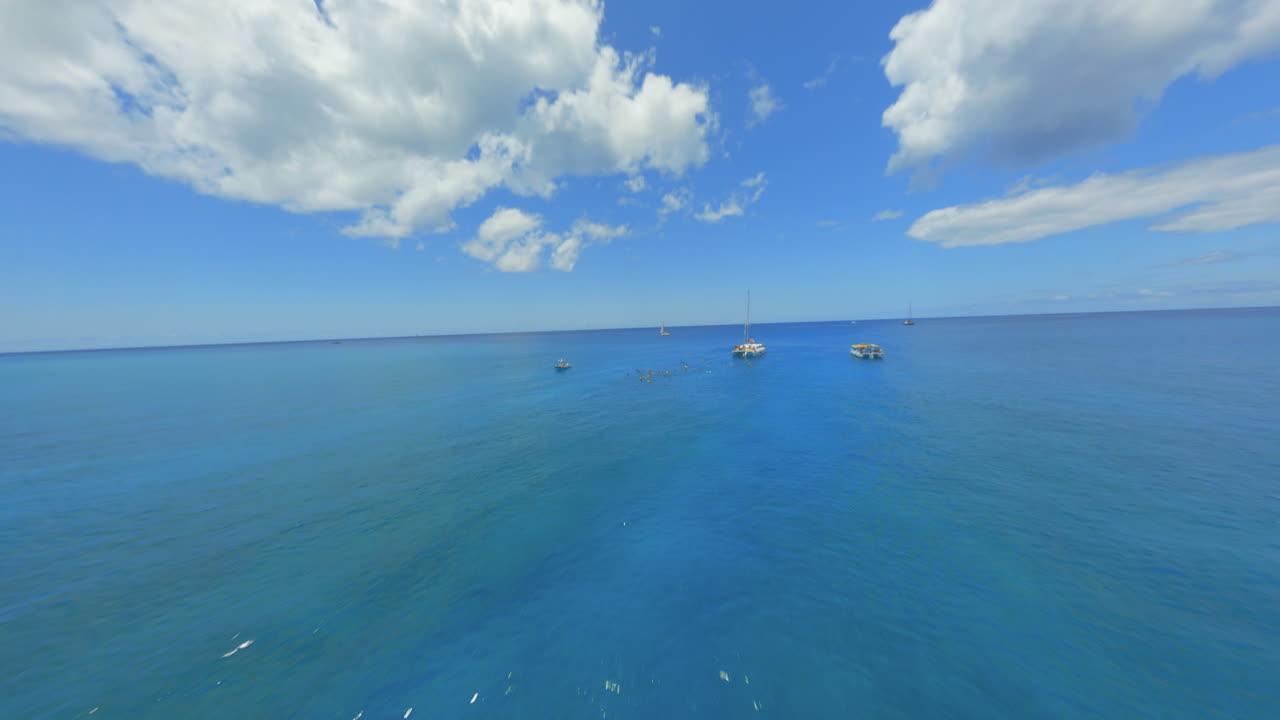 People Snorkeling and Sailing in a Tropical Ocean