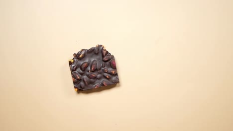 la mano del niño sosteniendo un pedazo de chocolate oscuro de pistacho