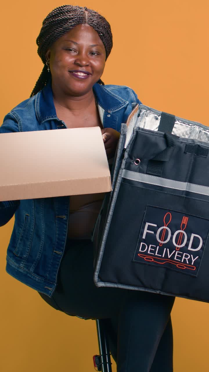 A woman delivering food with a pizza box