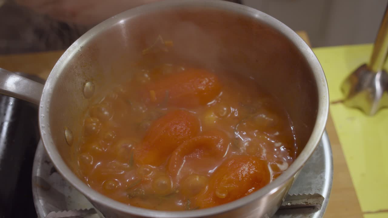 apertura de una olla de metal con sopa de verduras hirviendo en el interior
