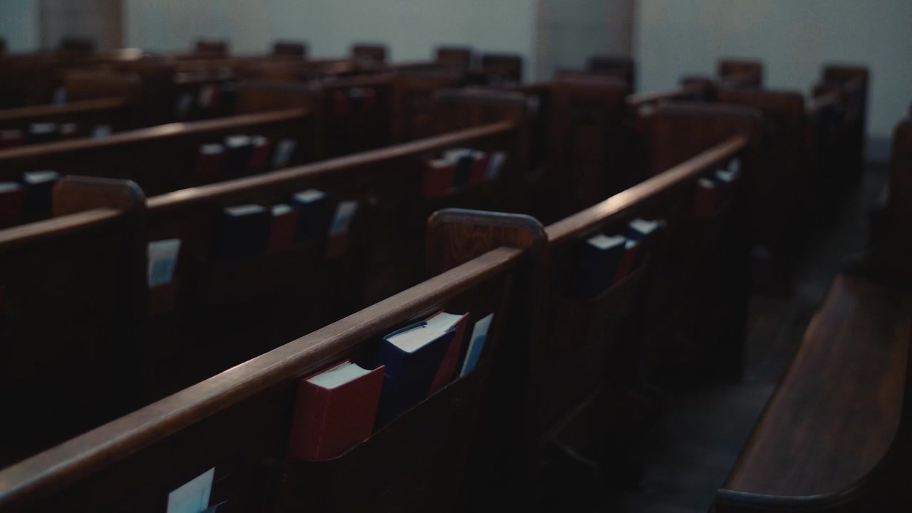 Banchi di chiesa in legno vuoti con innari in un interno silenzioso