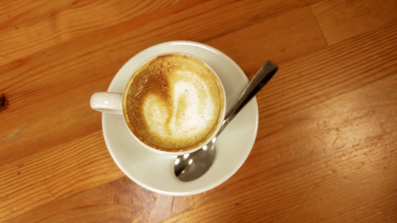 Tazza di cappuccino con latte art su un tavolo di legno