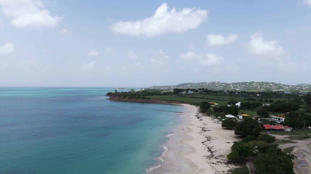 Fort James Beach in Antigua met turquoise water en wit zand onder een gedeeltelijk bewolkte hemel