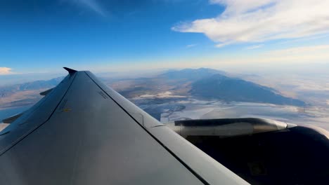 flying over the salt flats in utah on a commercial flight with the plane's wing in view