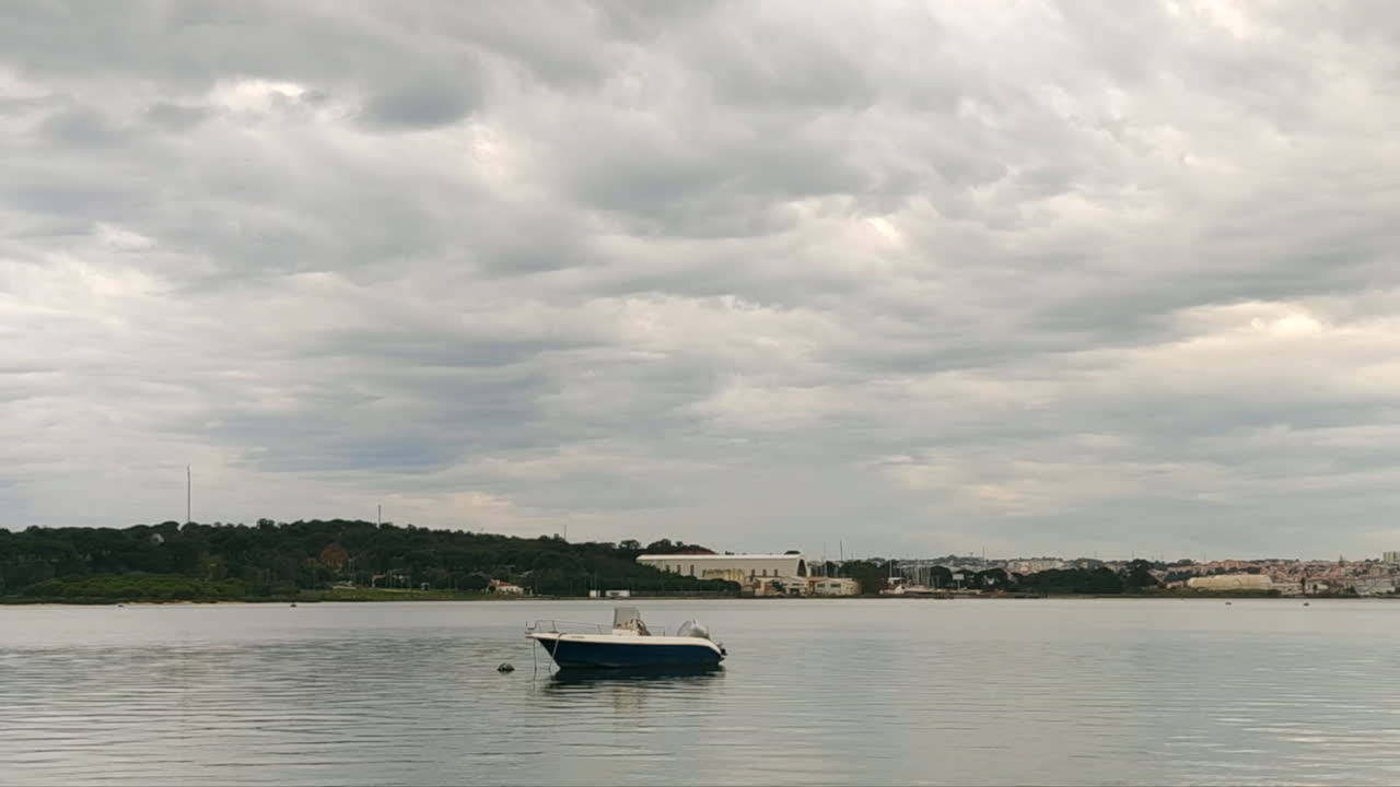 Barca vuota ormeggiata sul fiume con tempo nuvoloso - inquadratura statica