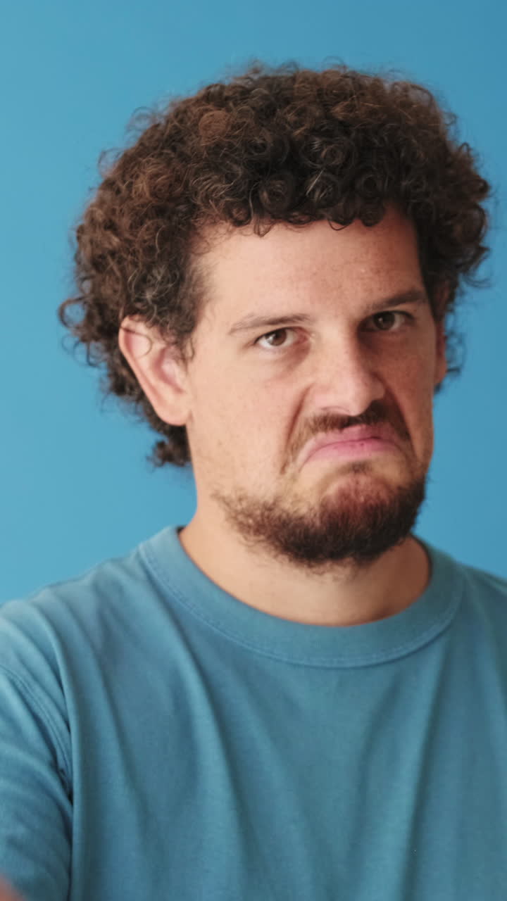 Uomo con espressione di disapprovazione che scuote la testa e punta il dito