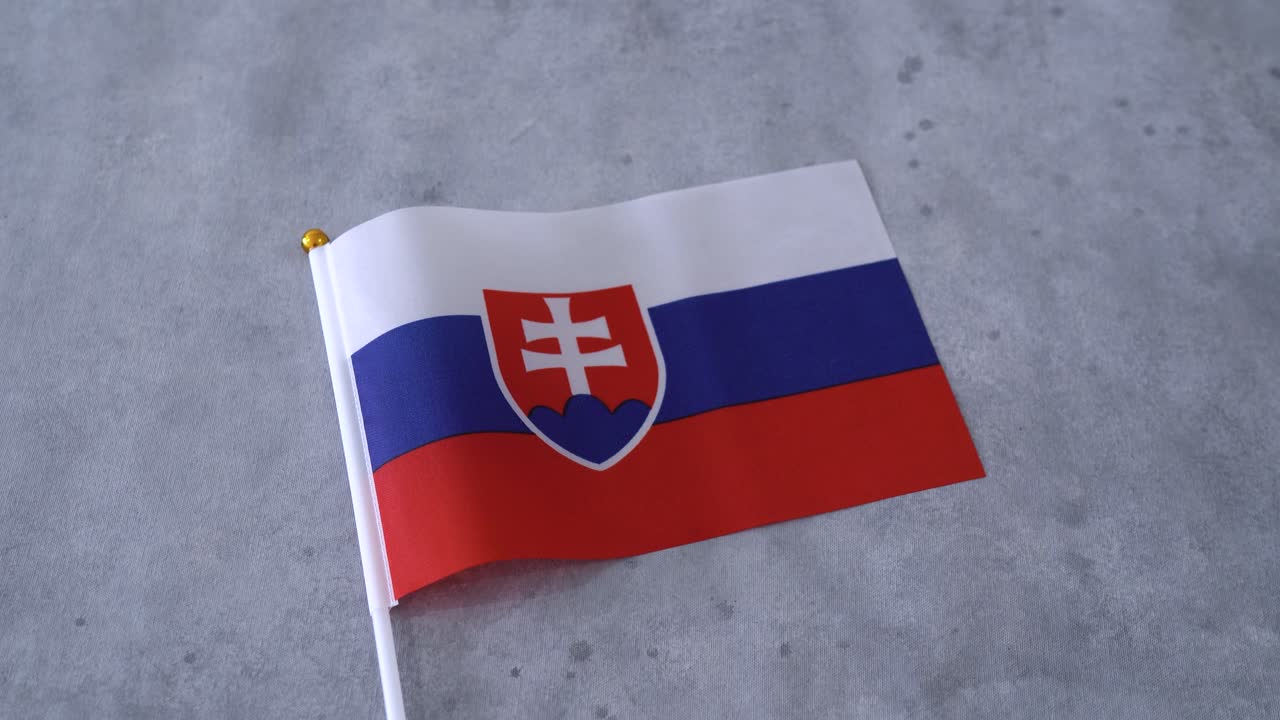Vlajka Slovenska zblízka na šedém pozadí. Slovenská národní vlajka.