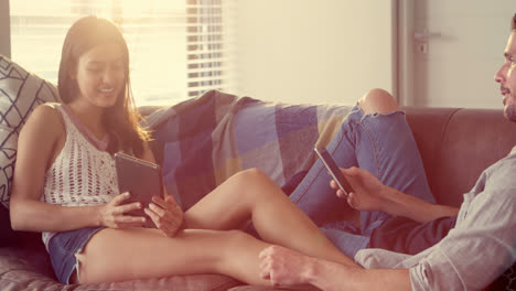 pareja usando teléfono móvil y tableta digital en la sala de estar 4k