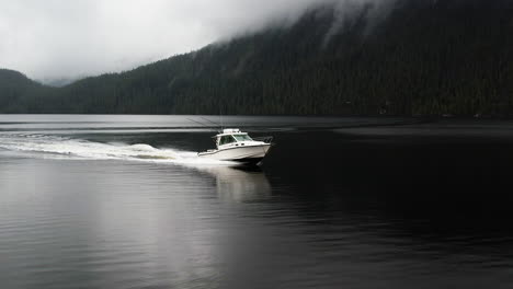 White-motor-boat-cruise-on-smooth-Clayoquot-Sound,-aerial-view