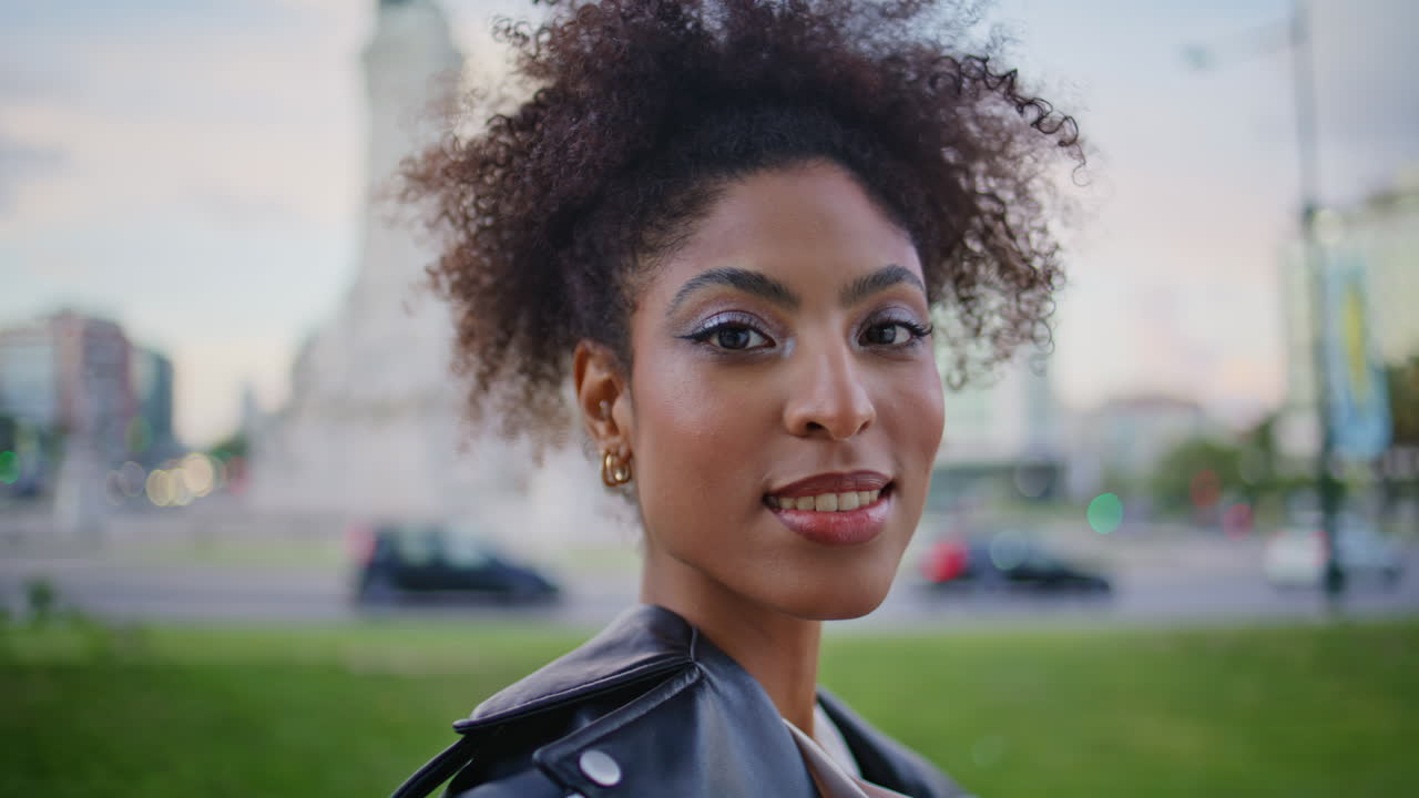 Mulher sorrindo e aproveitando a atmosfera da cidade em close-up na rua. Retrato de uma garota