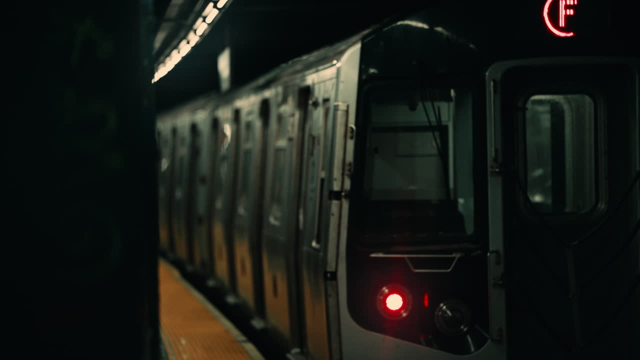 Treno della metropolitana in arrivo in una buia stazione sotterranea