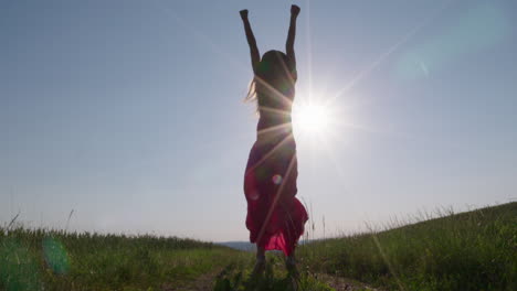 una mujer saltando en el aire frente al sol