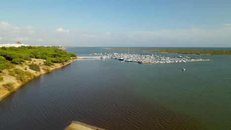 Aerial-drone-takeoff-over-docks-with-many-yachts-at-Piedras-river,-Puerto-Marina-El-Rompido,-Spain-daytime