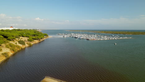 despegue aéreo de drones sobre muelles con muchos yates en el río piedras, puerto marina el rompido, españa durante el día