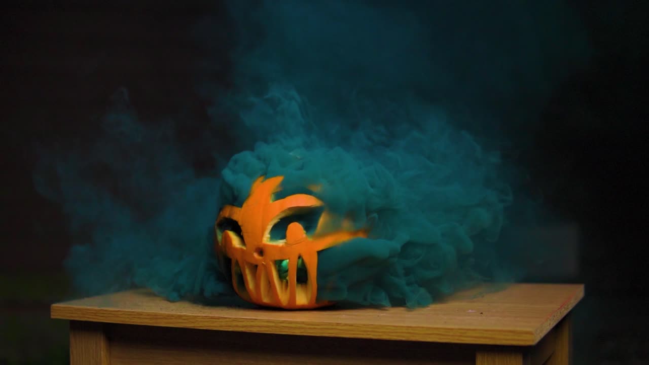 humo azul oscuro súper espeso y colorido que sale de la calabaza tallada en cámara lenta
