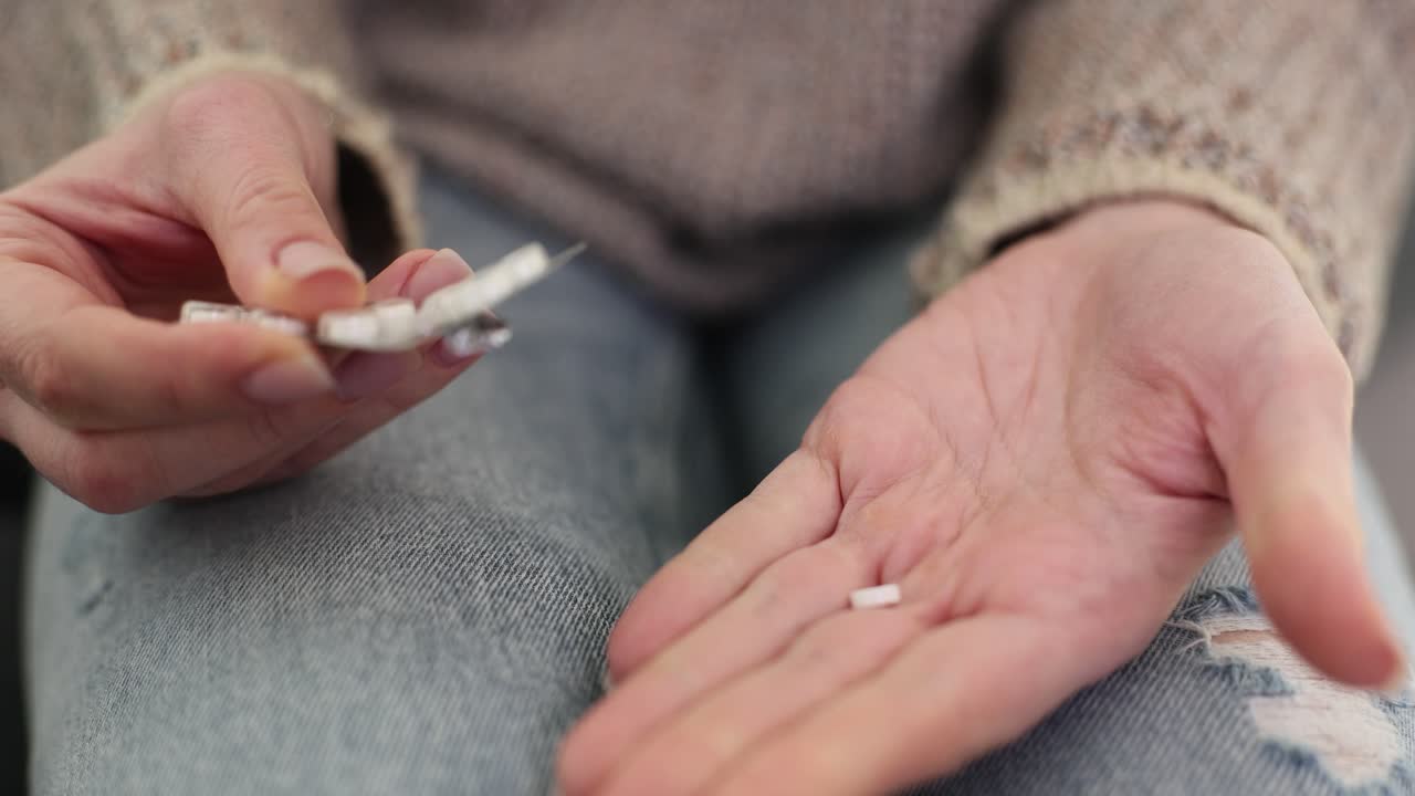 Woman taking pills from blister pack