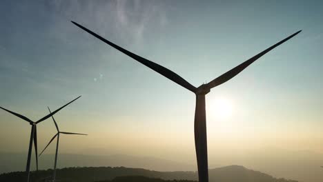 wind power hill with rotating blades in the brilliant morning sunlight in da lat - vietnam