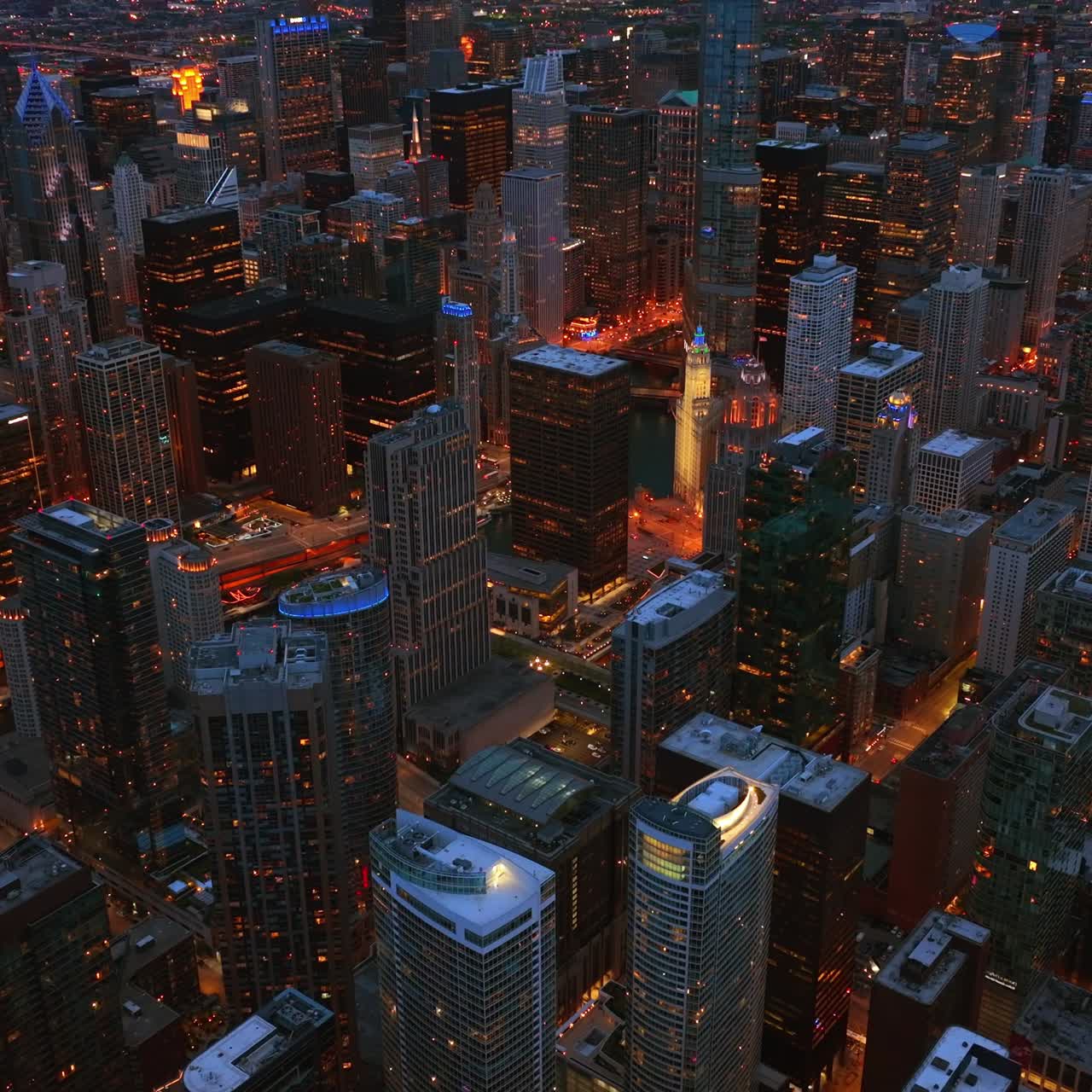 Evening sight of amazing Chicago scenery. Well-lit streets going among the sparkling skyscrapers from aerial perspective