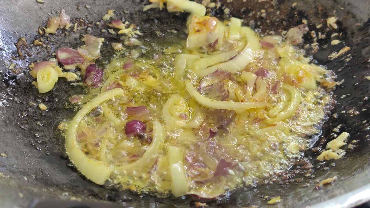 Cebolas salteadas, anchovas e açafrão-da-terra fritam em uma panela. Essa etapa essencial do Sudeste Asiático cria um aroma profundo. O açafrão-da-terra é adicionado para criar um belo tom amarelo-dourado.
