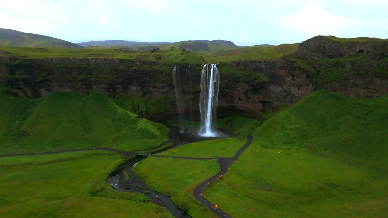 Discover the hidden beauty of Seljalandsfoss from the sky, where the waterfall’s mist dances in the sunlight.