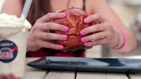 women picks up a delicious looking burger