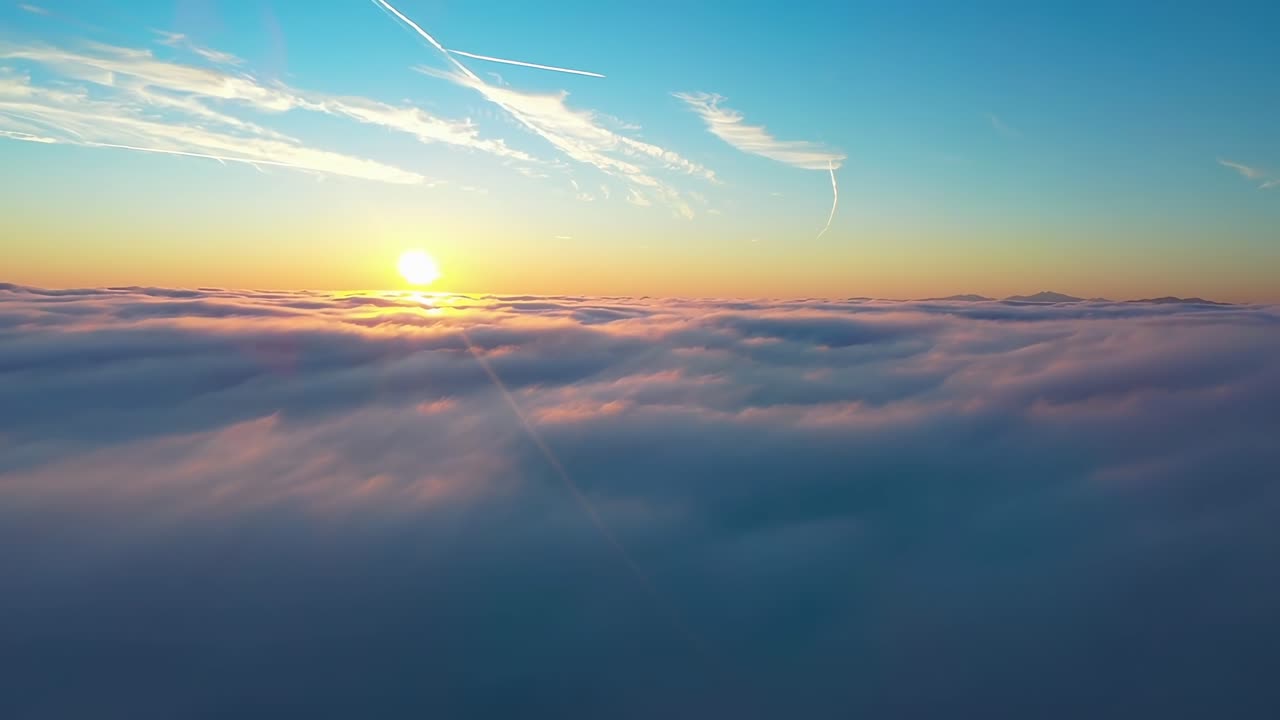 Un video aereo riprende una serena alba sopra le nuvole, con una vista grandangolare dell'orizzonte.