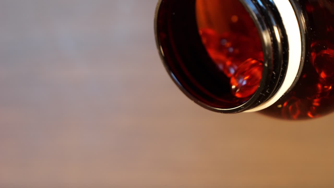 vertiendo cápsulas de naranja píldoras de omega 3 como símbolo de sobredosis de drogas, cayendo de un frasco en cámara lenta