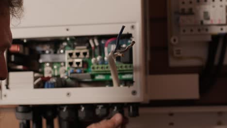 an electrician installing an inverter in a home. the image shows technical skill, modern tools, and attention to safety in electrical work