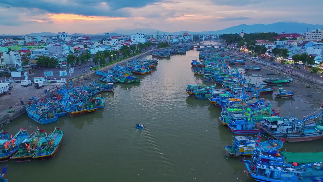 드론 뷰 바구니 보트 (drone view basket boat) 는 베트남 중부 비앙투안 지방의 티 (phan thiet) 시에 있는 카타이 강 (cai thi) 에 있는 시 보트 (fishing boats) 를 가로질러 이동하고 있다.