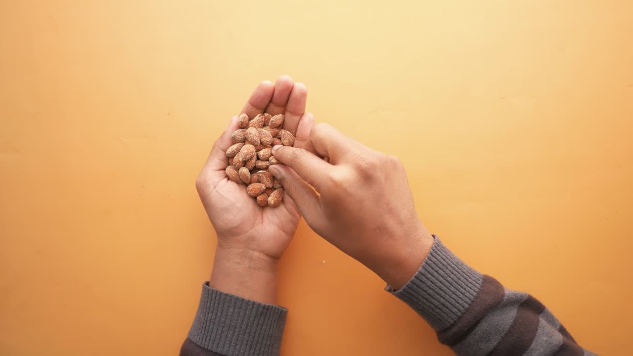 Close up of almond nuts on mans hand