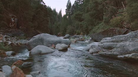 Flying-over-mountain-river,-slow-aerial-push-in-establishing-shot